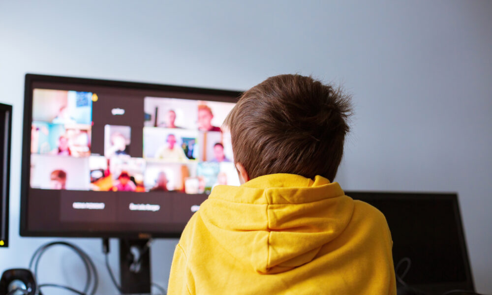 Schüler vor Bildschirm bei Videokonferenz im Homeschooling